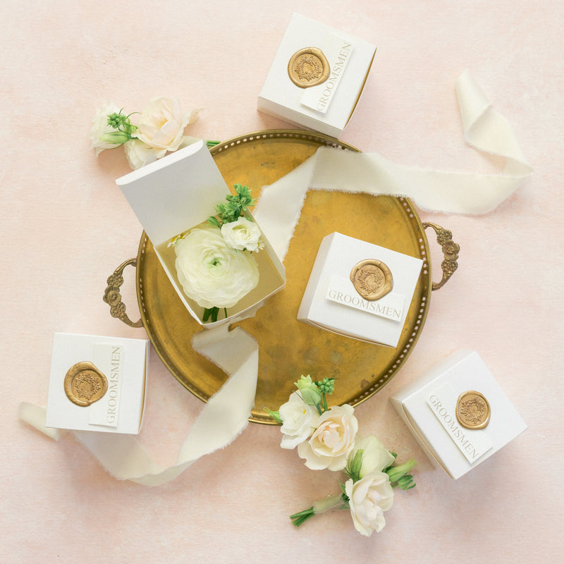 Decorative arrangement of white boxes with gold accents on a pink background