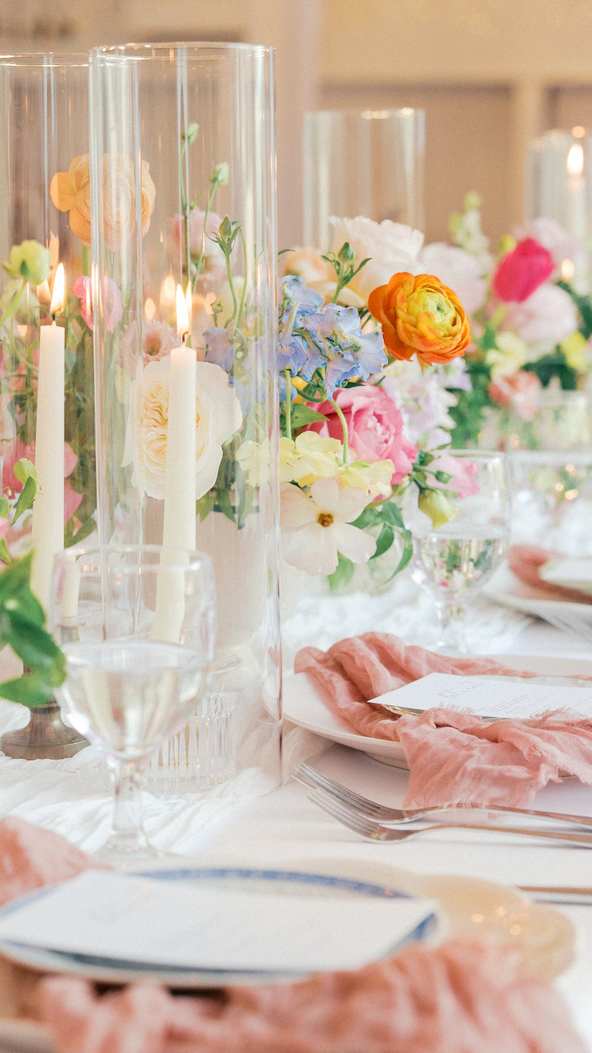 Elegant table setting with floral centerpieces and candles in a formal dining room. long tablescape floral arrangement with seasonal blooms and soft greenery for editorial wedding