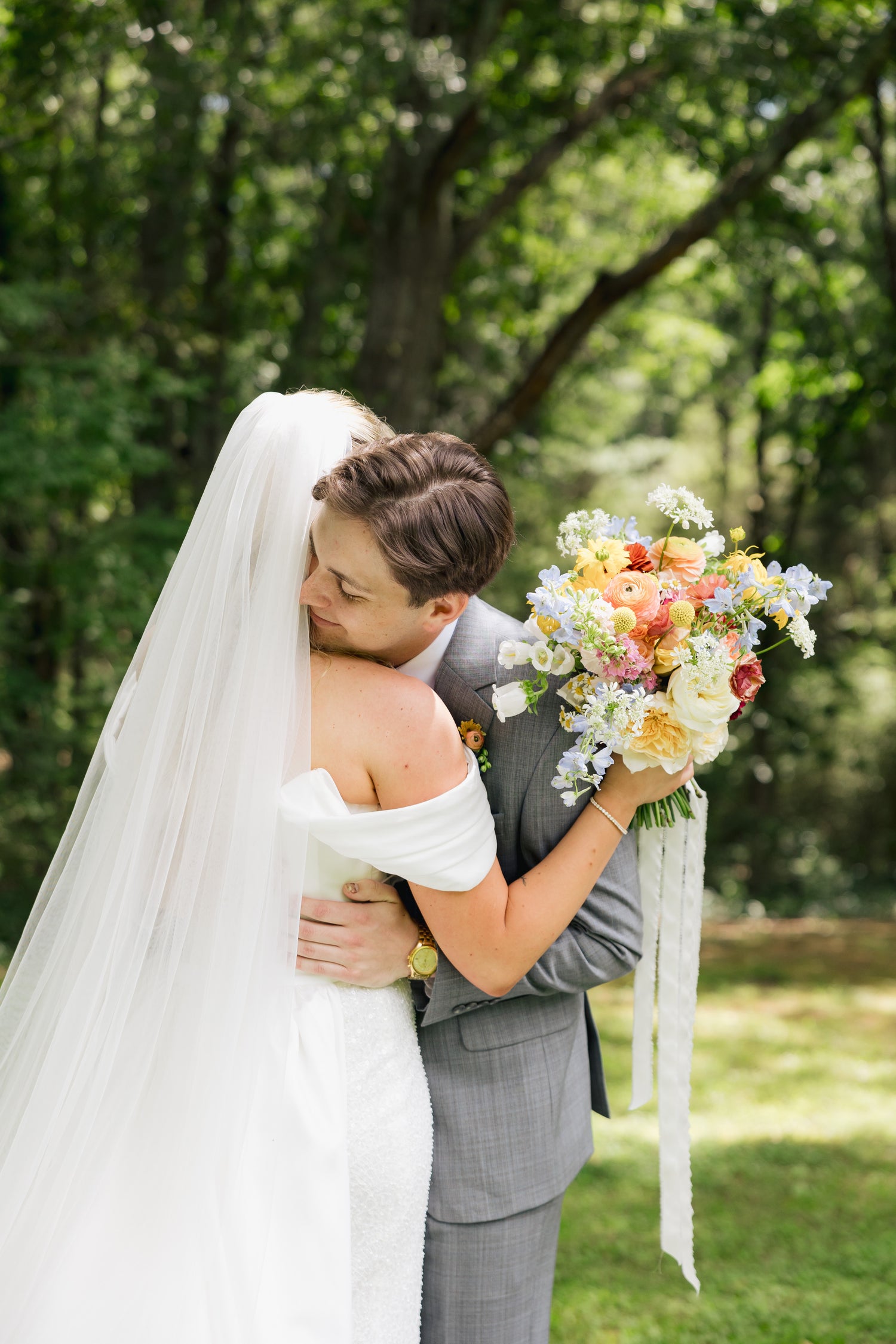 Couple embracing outdoors with a bouquet of flowers in the foreground