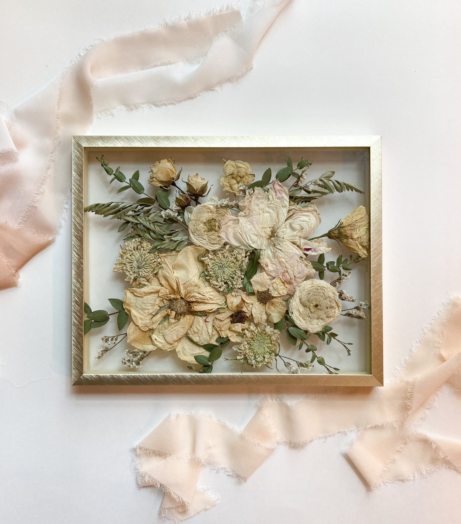 Framed arrangement of pressed flowers on a light background with ribbons. Preserve bridal bouquet quickly, atlanta georgia